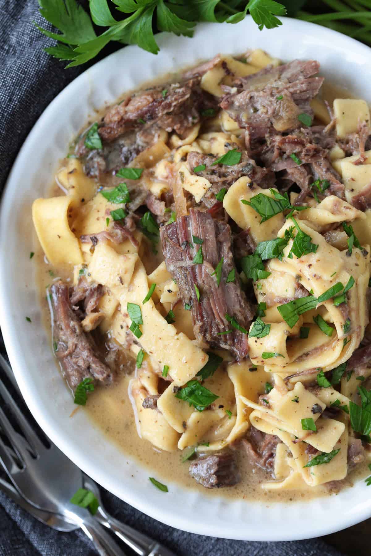 shredded beef and noodles in a bowl with gravy