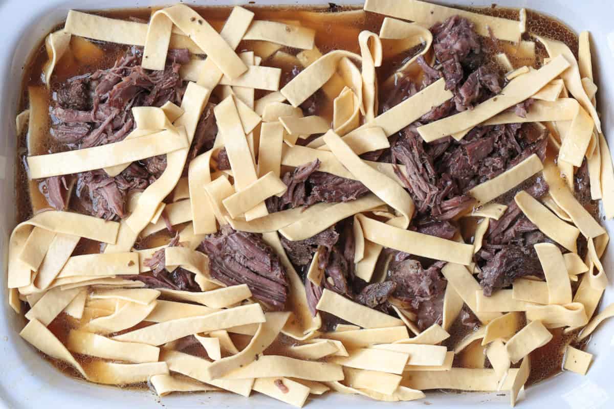 noodles with shredded beef and broth in slow cooker