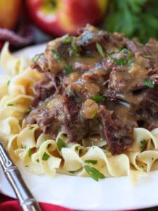 pot roast with gravy on a plate with noodles