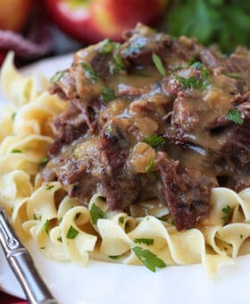 pot roast with gravy on a plate with noodles