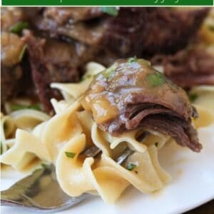 pot roast over noodles with text overlay for pinterest