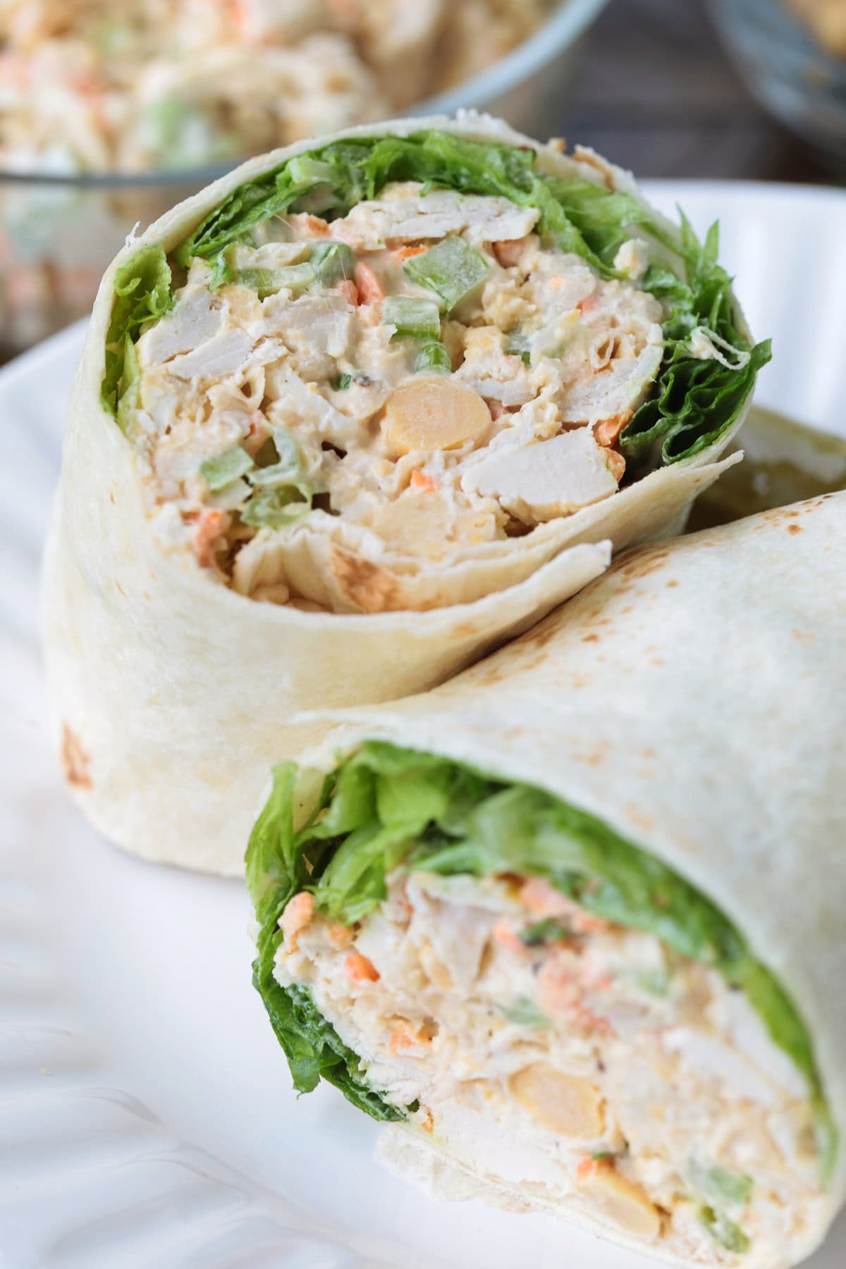 Chickpea Chicken Salad is made with tender chicken, crunchy veggies and buttery chickpeas. A protein packed meal that's ready in minutes! chicken salad wrap cut in half and stacked on a plate