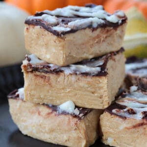 pumpkin fudge cut into squares and stacked on a black plate