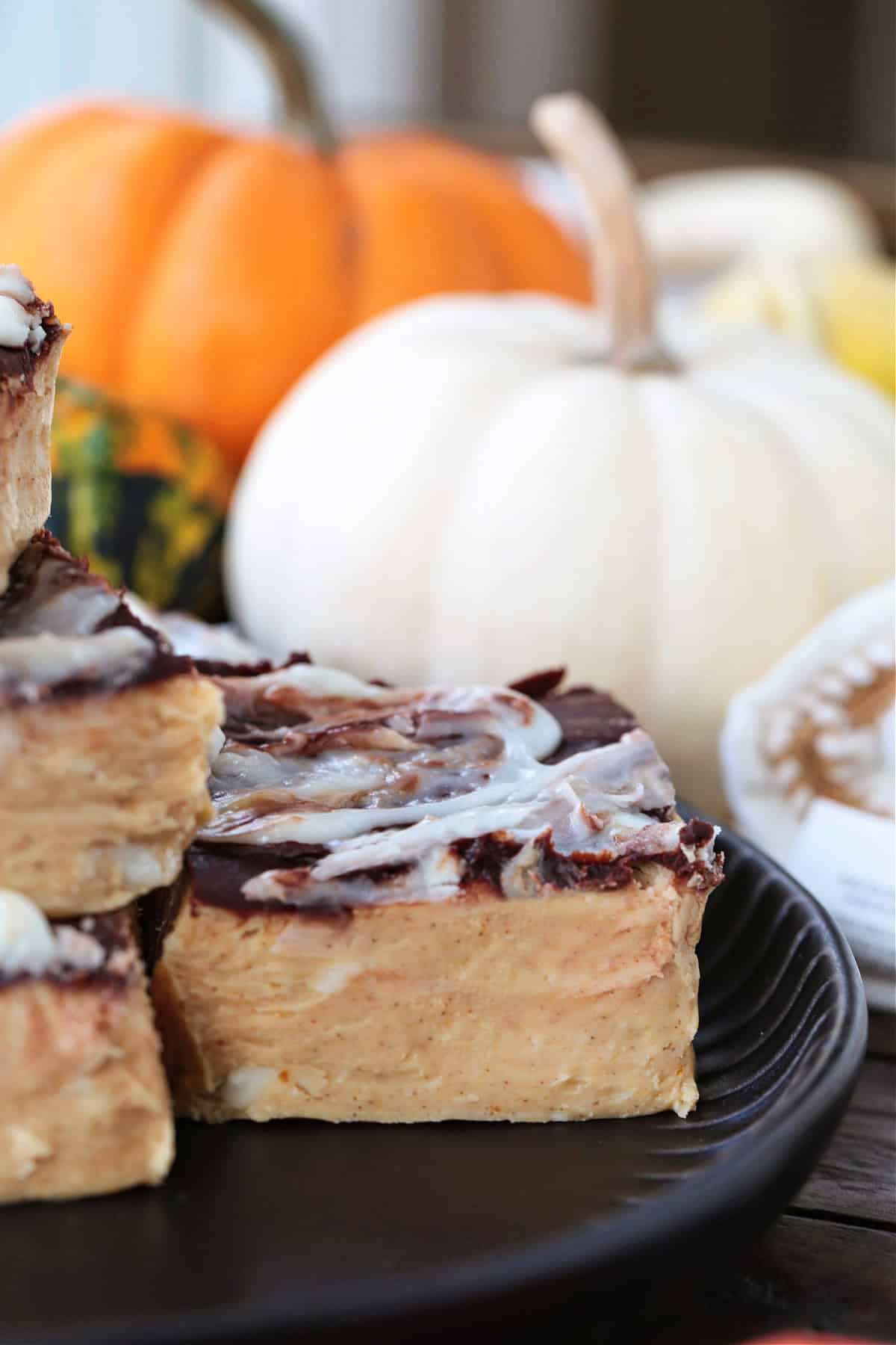 a piece of fudge on a black plate with a white pumpkin
