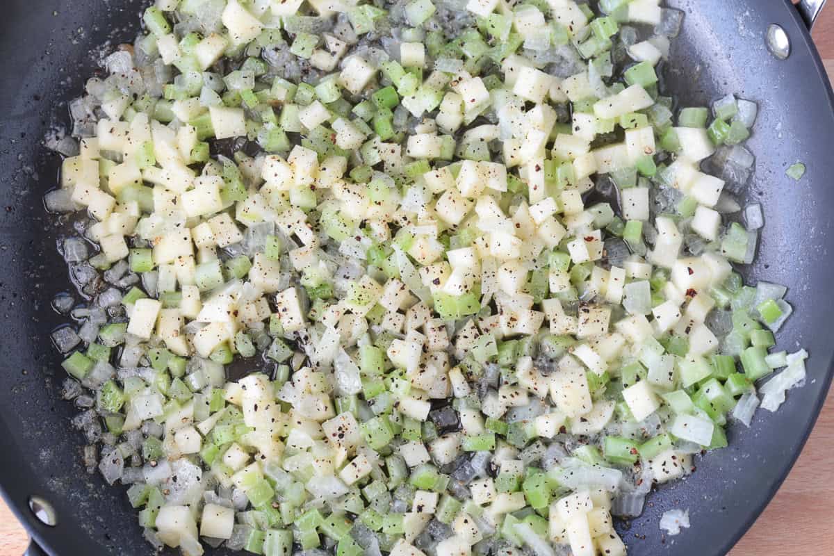 onions, apples and celery cooking in butter in a skillet