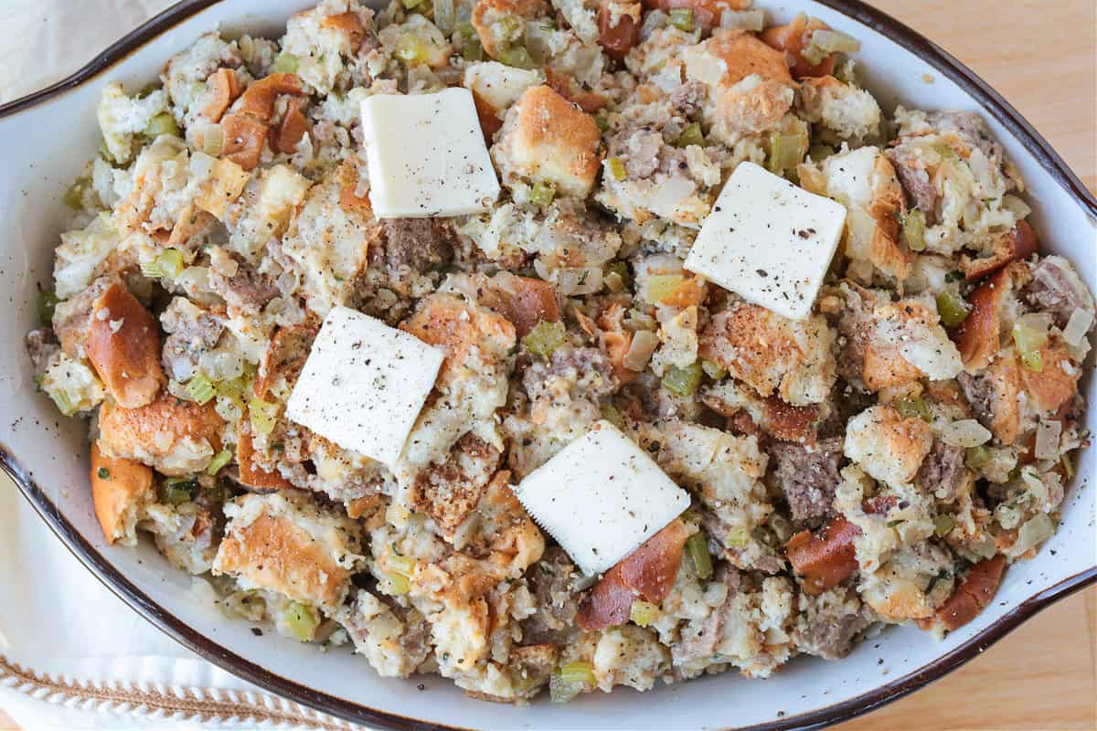 stuffing recipe in a baking dish with pats of butter