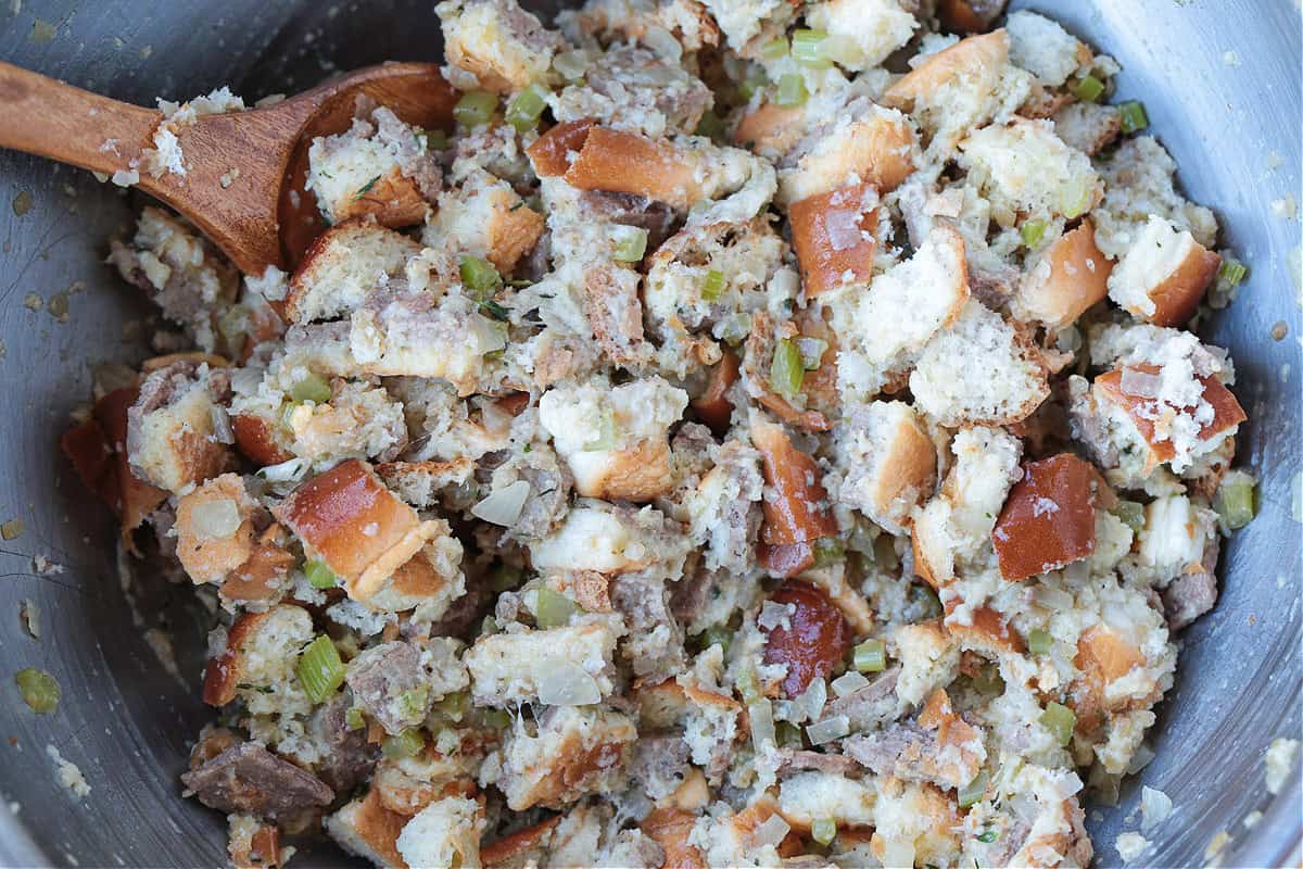 bread cubes and vegetables in a bowl with wooden spoon