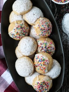 italian wedding cookies on black platter with checkered napkin