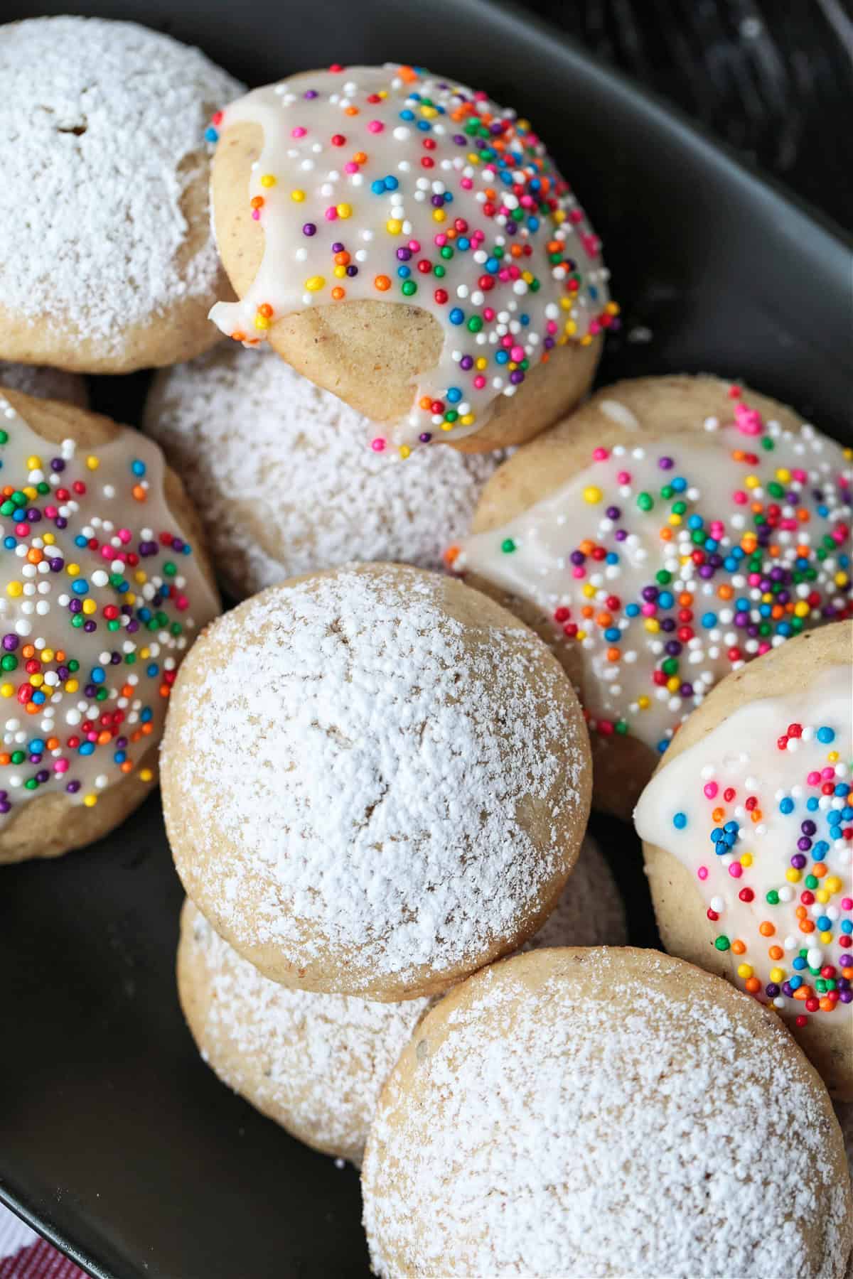 decorated snowball cookies on a black platter
