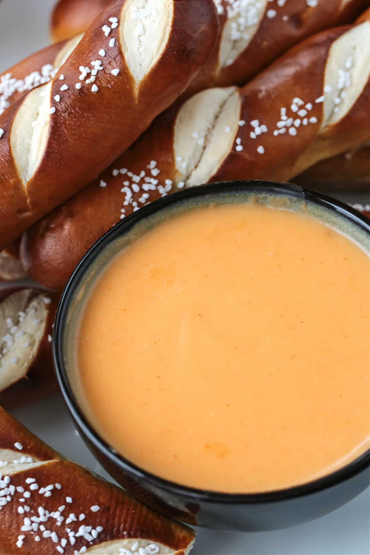 close up of pretzel sticks on a platter with beer cheese sauce