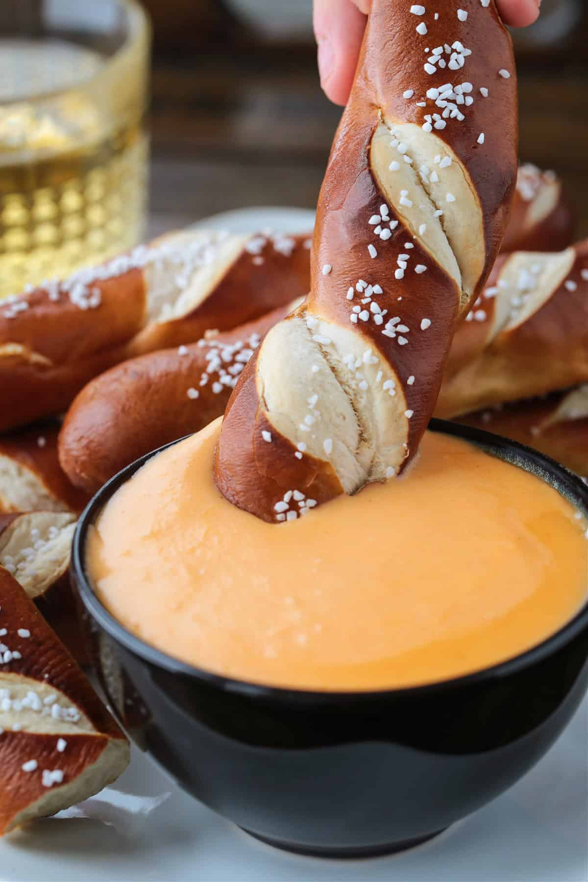 pretzel stick dipping into beer cheese dip