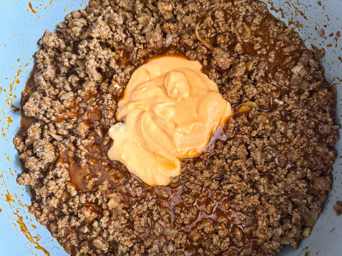 sloppy joe meat in a skillet with cheese sauce