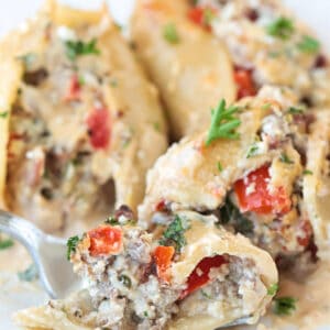 fork on a plate with a bite of cheesesteak stuffed shells