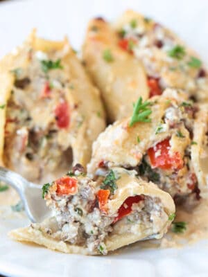 fork on a plate with a bite of cheesesteak stuffed shells