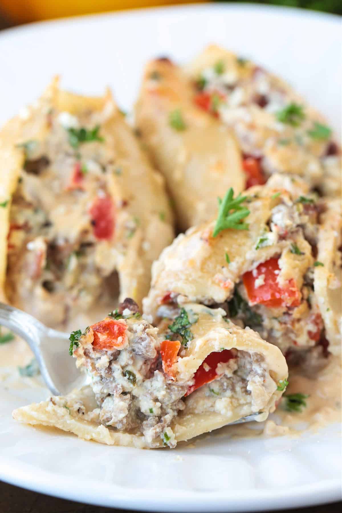 fork on a plate with a bite of cheesesteak stuffed shells