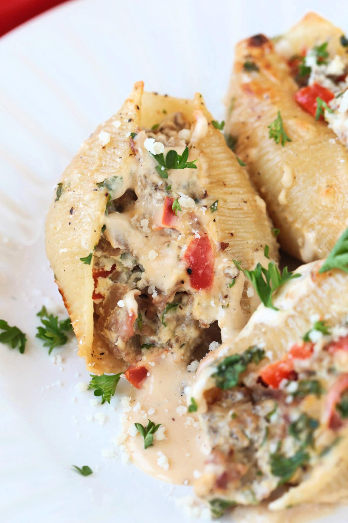 stuffed shells with shaved beef and pepper filling on white plate