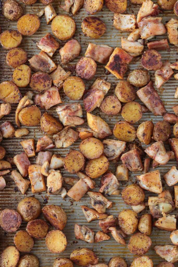 diced potatoes and chicken thighs on a sheet pan