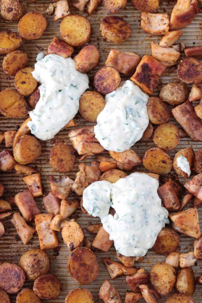 garlic parmesan sauce on  top of diced chicken and potatoes