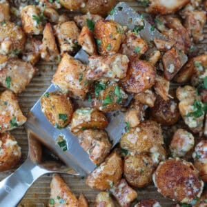 chicken and potatoes on a spatula baked on a sheet pan