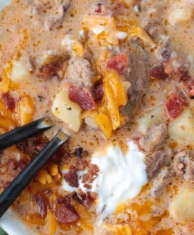 cheeseburger soup in a bowl with two spoons