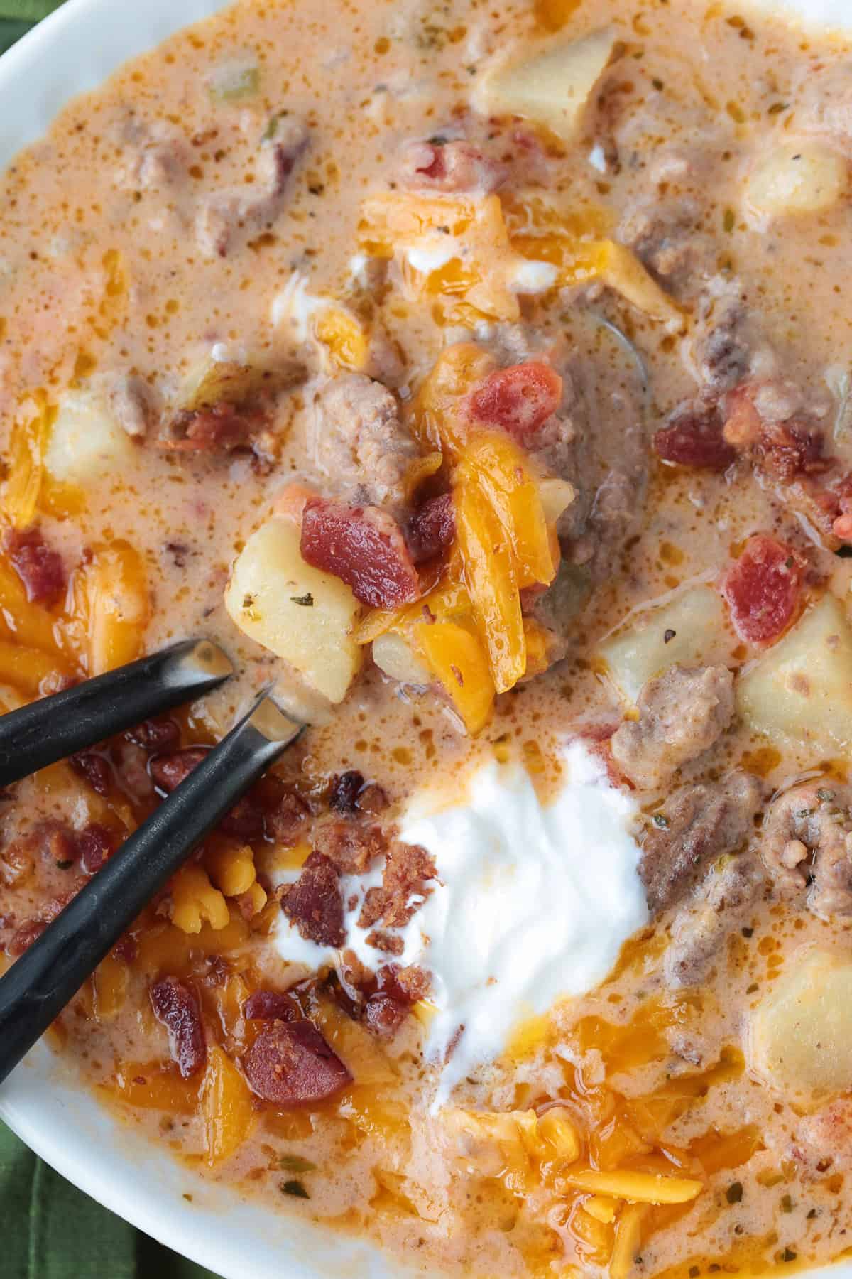 Rich and creamy cheeseburger soup is packed with ground beef, real cheddar cheese and potatoes for the ultimate cozy comfort food dinner. cheeseburger soup in a bowl with two spoons