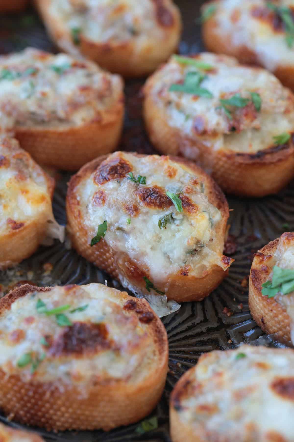 close up of sausage crostini on a baking sheet