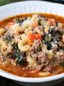 side view of a bowl of minestrone soup with sausage