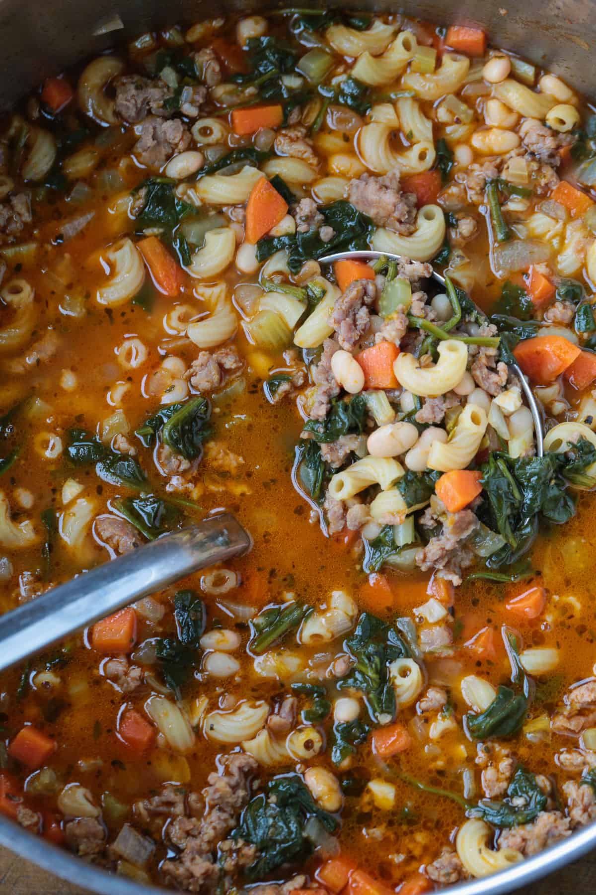 sausage minestrone soup in a pot with ladle