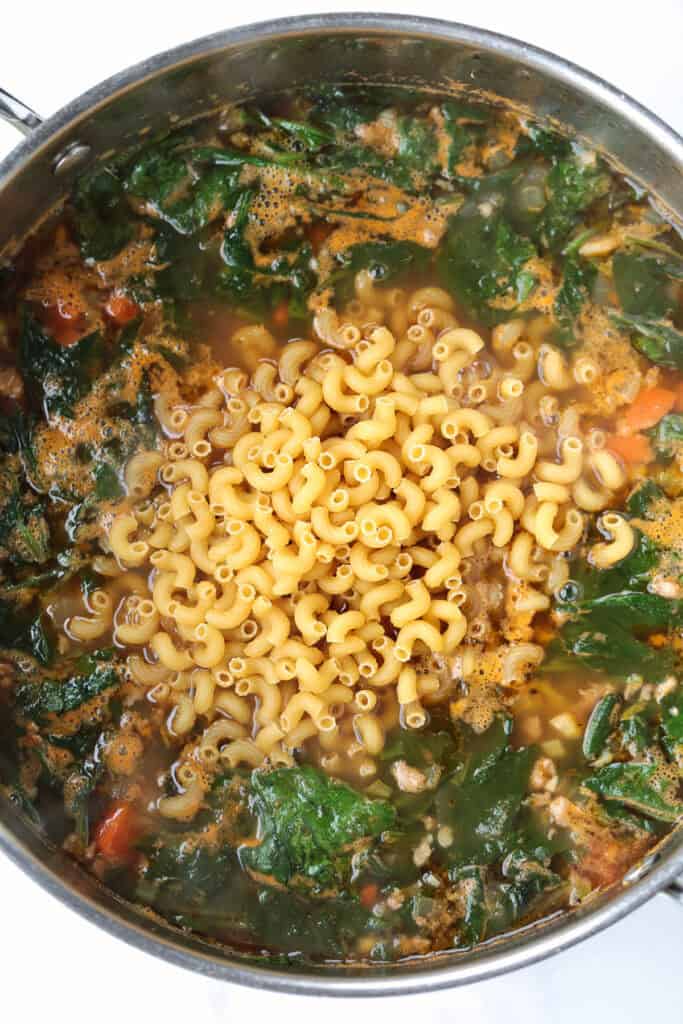 elbow pasta in a pot of soup