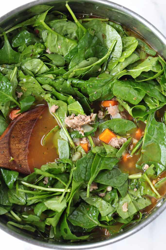 fresh spinach in a pot of soup