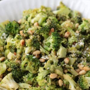 shaved broccoli with pignoli nuts in a bowl with parmesan cheese