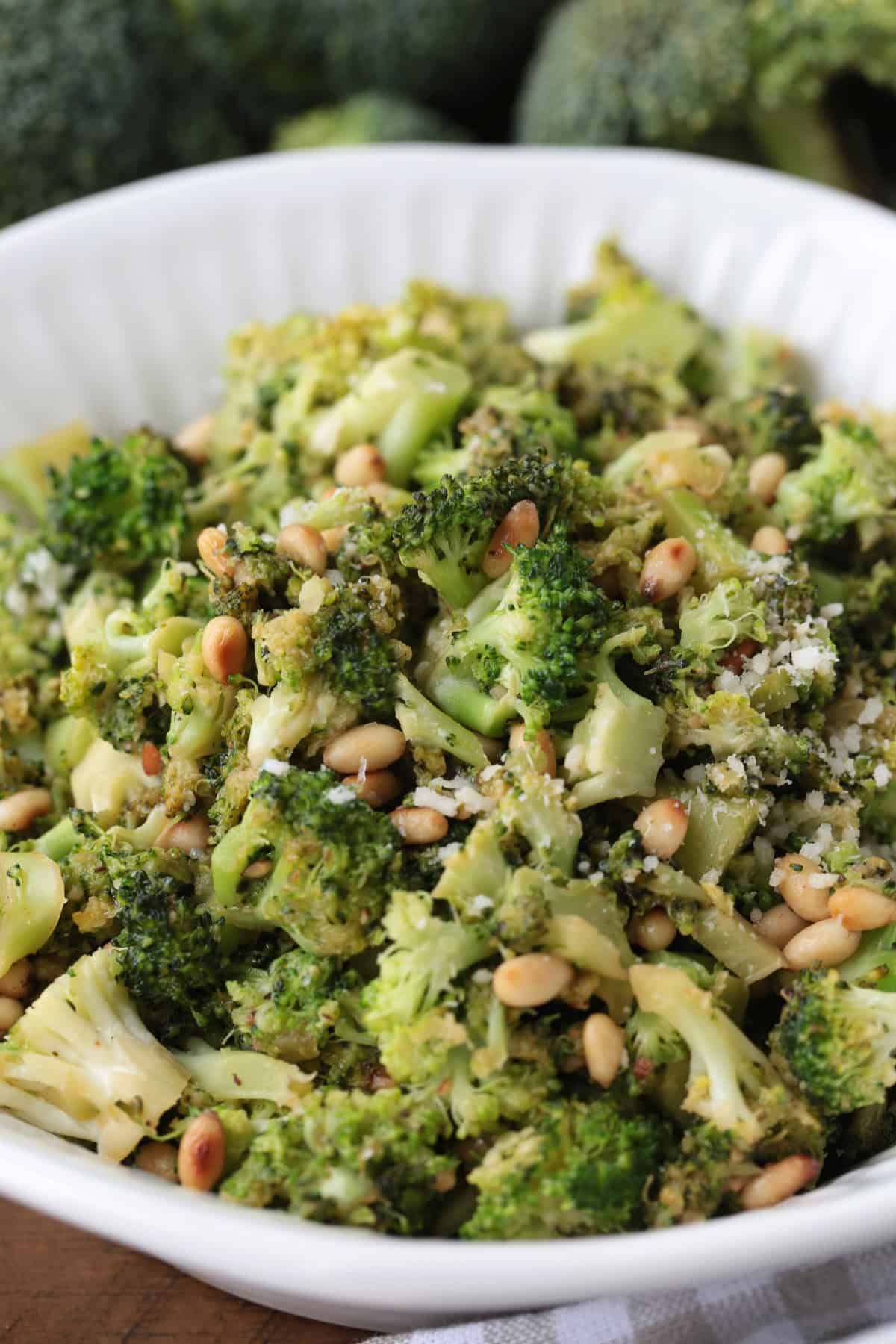 shaved broccoli with pignoli nuts in a bowl with parmesan cheese