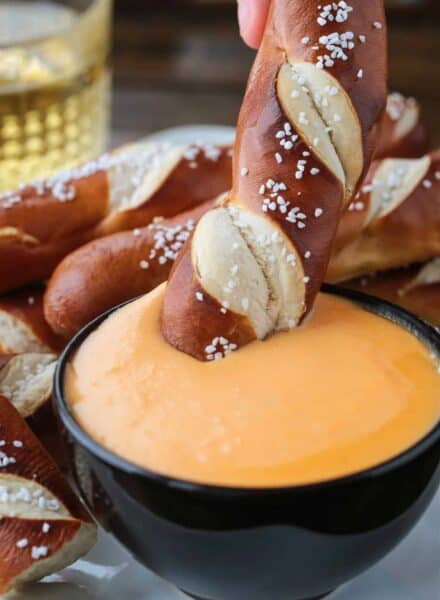 pretzel stick dipping into beer cheese dip