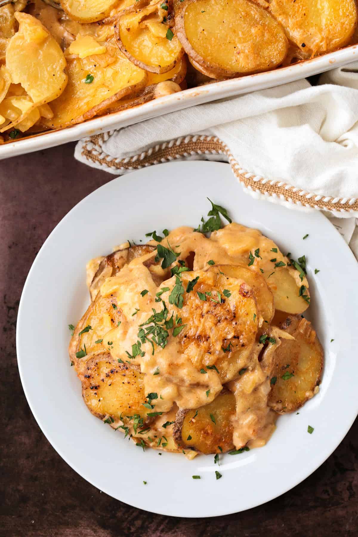 white plate with a serving of cheesy potato casserole