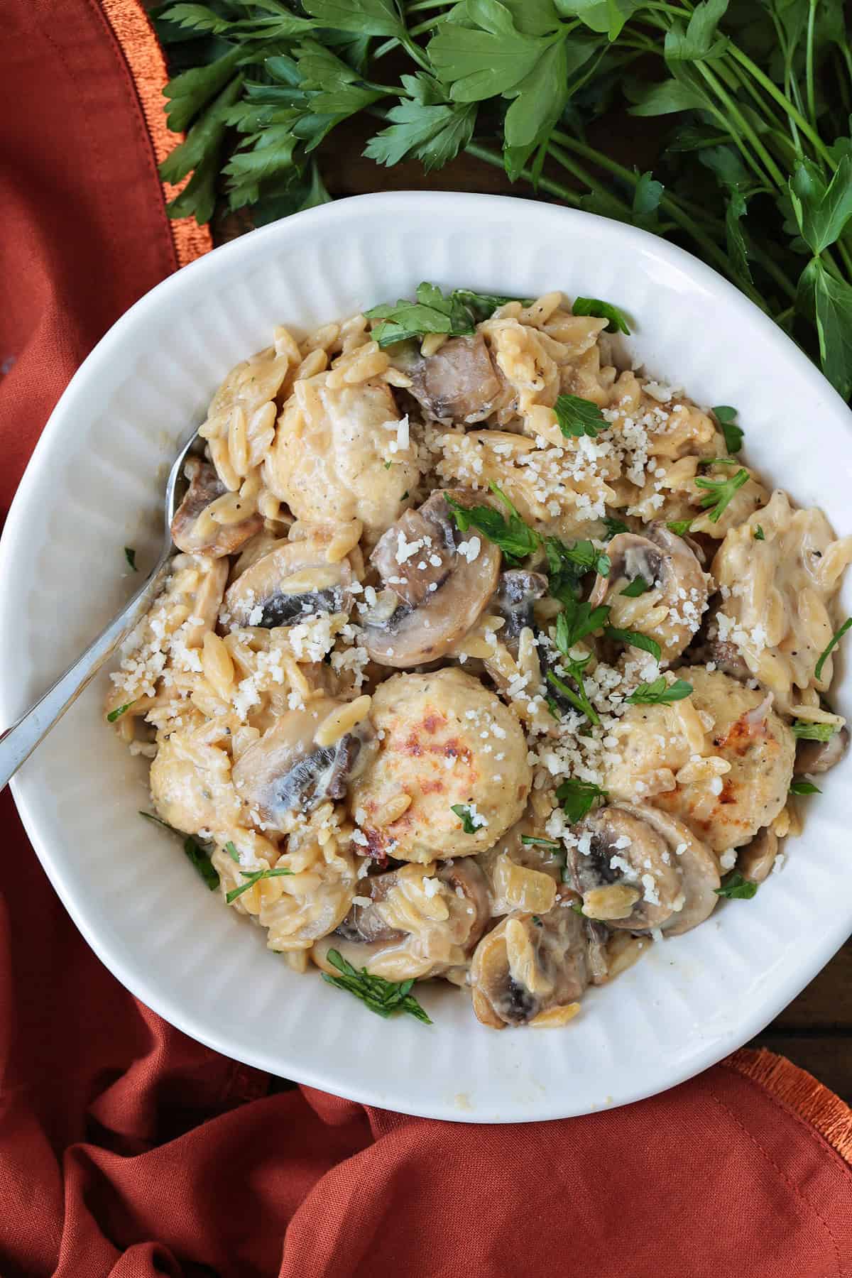 white bowl with chicken meatballs and mushroom orzo with parsley