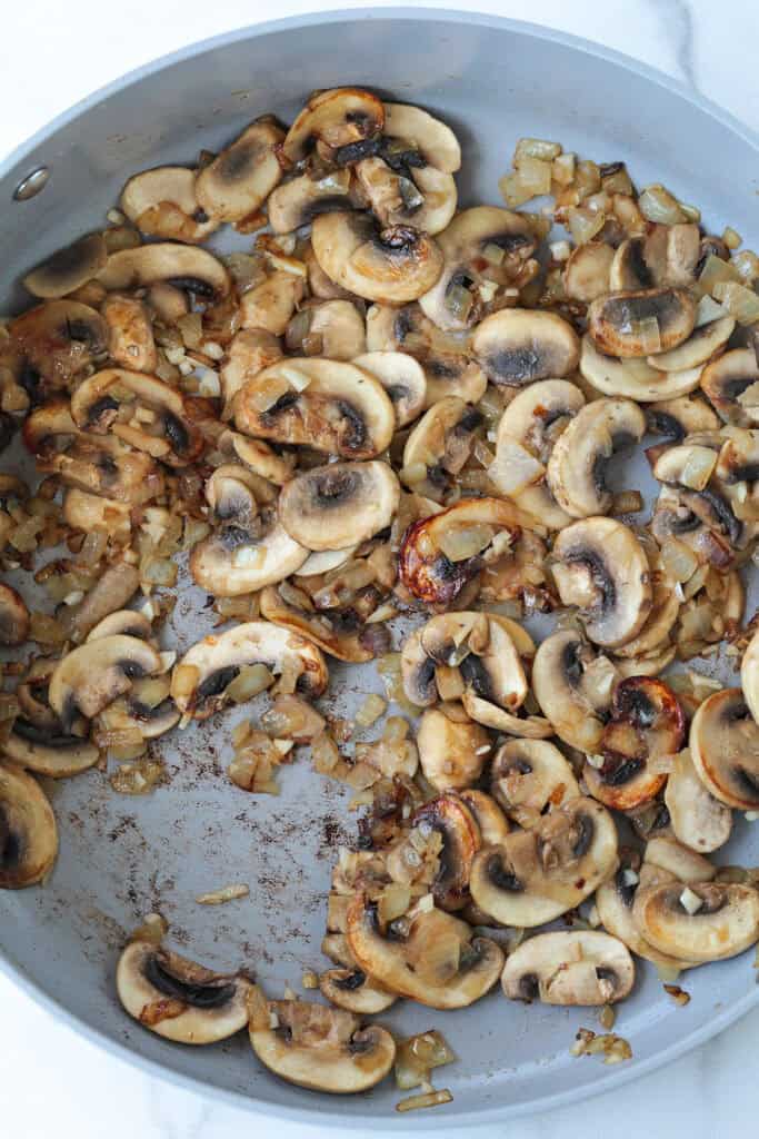 sliced mushrooms browning in skillet