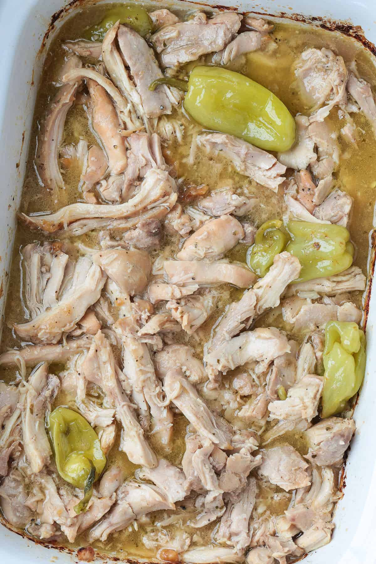Mississippi Chicken is an easy, 5 ingredient dinner! Tender chicken in a tangy and zesty gravy spooned over mashed potatoes or noodles! shredded chicken in slow cooker with pepperoncini peppers