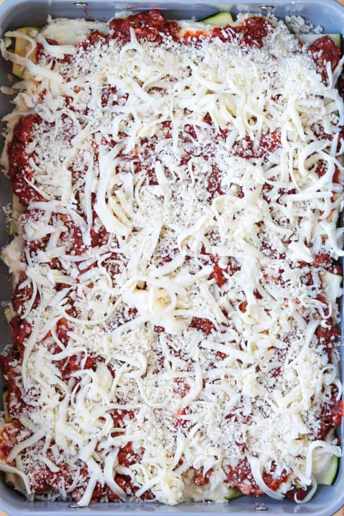 Our Fool Proof Zucchini Lasagna turns out perfect every time. Thin strips of zucchini make a lighter lasagna recipe with tons of flavor! layers of sauce, zucchini and cheese in baking dish