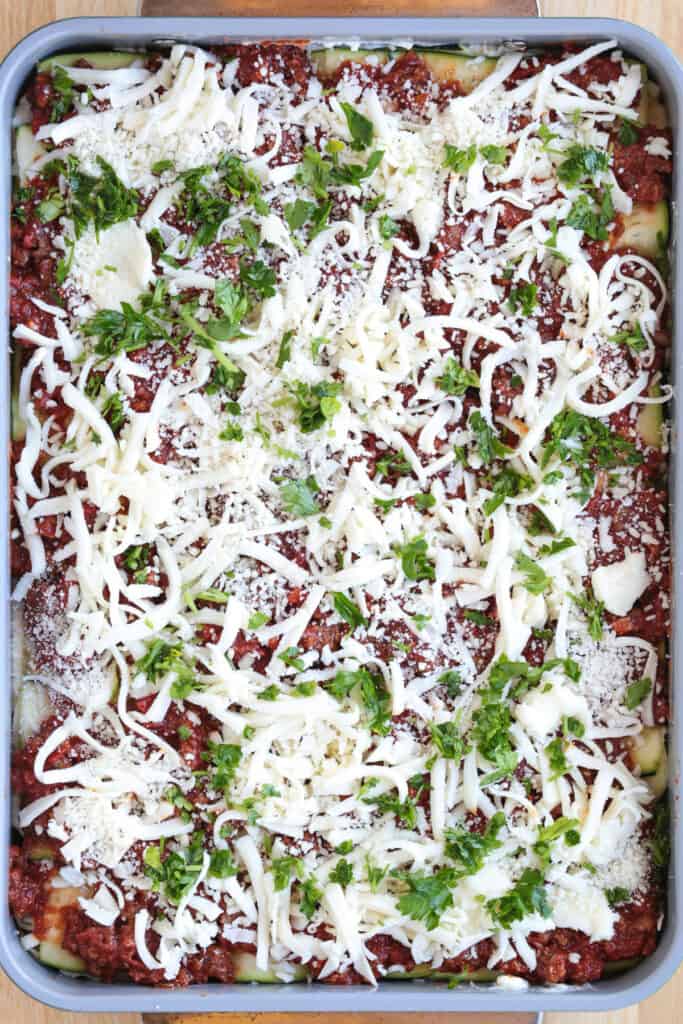 Our Fool Proof Zucchini Lasagna turns out perfect every time. Thin strips of zucchini make a lighter lasagna recipe with tons of flavor! layers of zucchini, cheese and meat sauce in baking dish topped with parsley