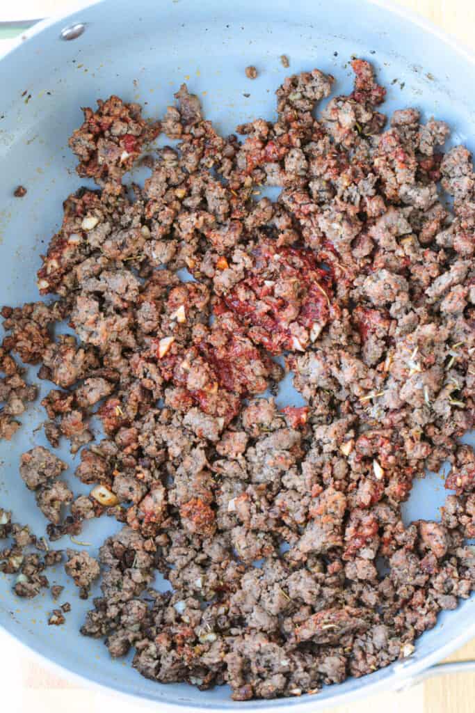 Our Fool Proof Zucchini Lasagna turns out perfect every time. Thin strips of zucchini make a lighter lasagna recipe with tons of flavor! ground beef in a skillet with seasonings and tomato paste