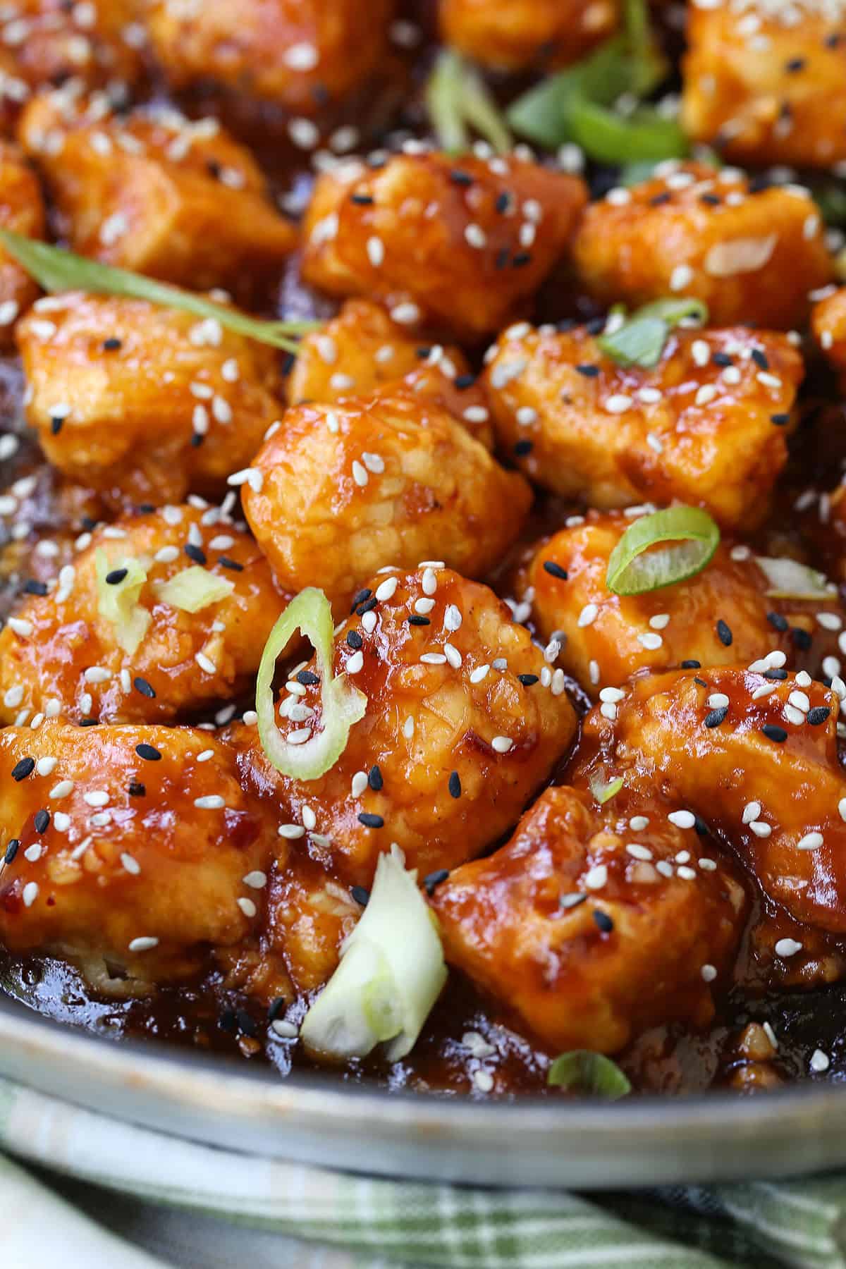 Air Fryer General Tso's Chicken is a lighter take on the take-out recipe that you'll love. The same flavors you crave but without the oil. close up of general tso's chicken garnished with scallions and sesame seeds