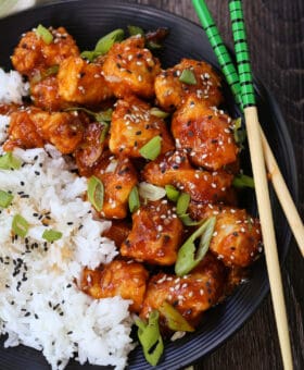 general tsos chicken with rice and chopsticks