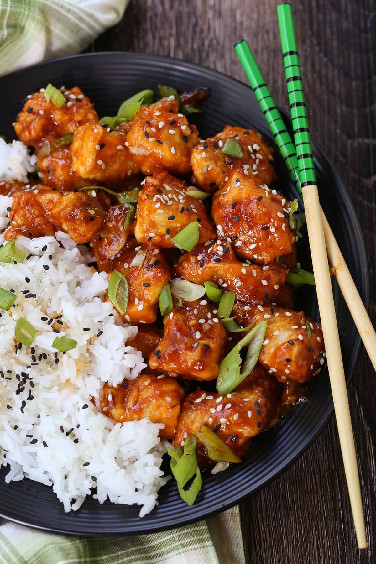 Air Fryer General Tso's Chicken is a lighter take on the take-out recipe that you'll love. The same flavors you crave but without the oil. general tsos chicken with rice and chopsticks