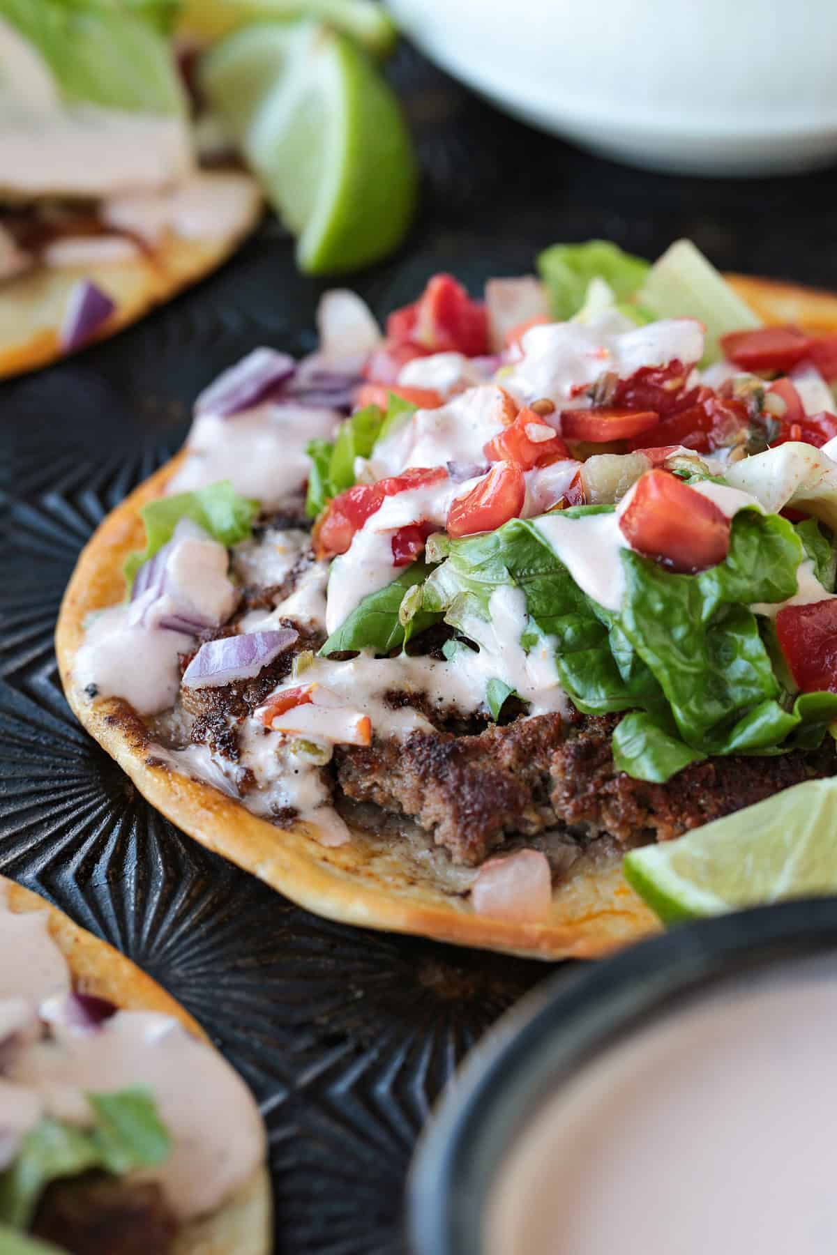 Smash Tacos are the key to fun dinners that everyone loves. Seasoned ground beef cooked on a crispy tortilla with your favorite toppings! ground beef tortilla taco with sauce and toppings
