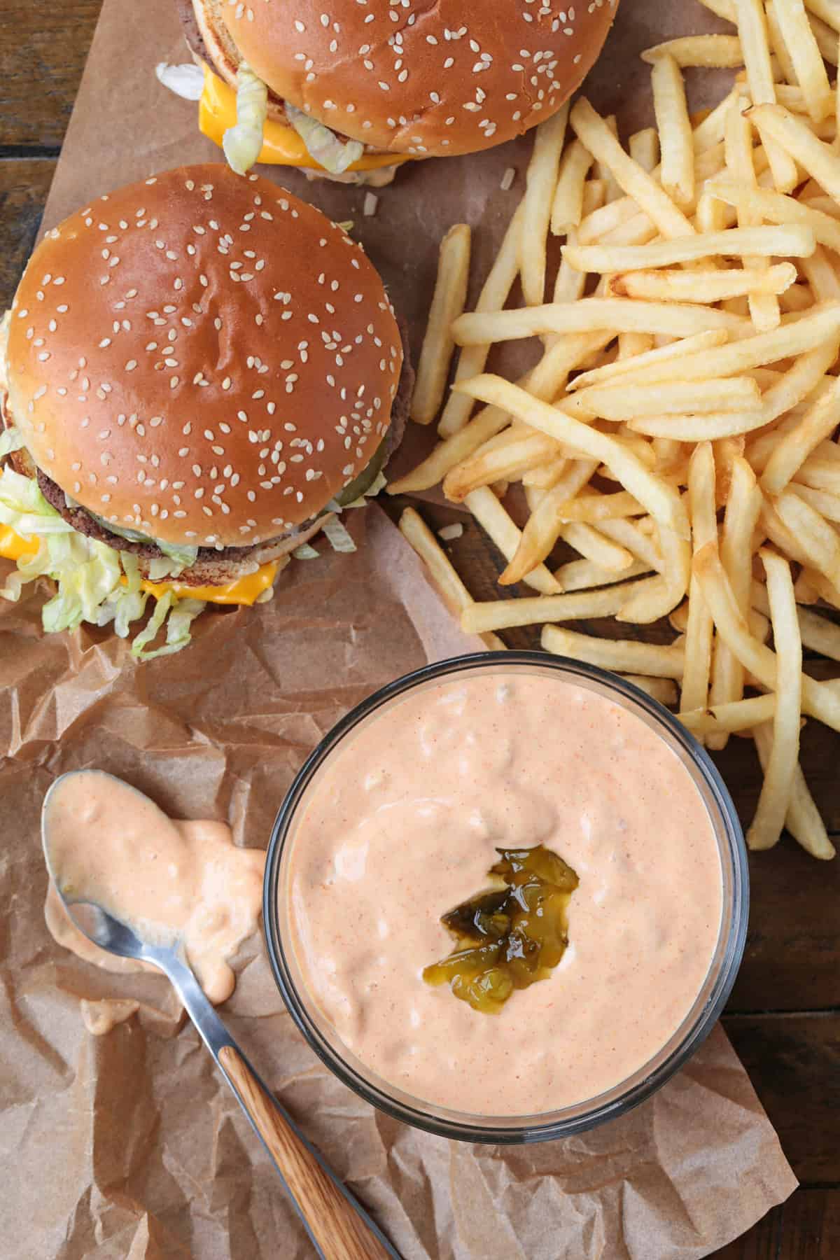 big mac and fries on a board with sauce in a bowl