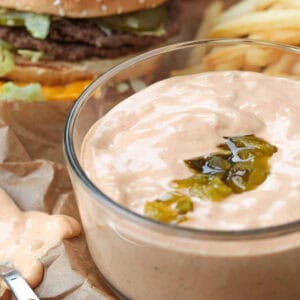 bowl of big mac sauce with a cheeseburger in background