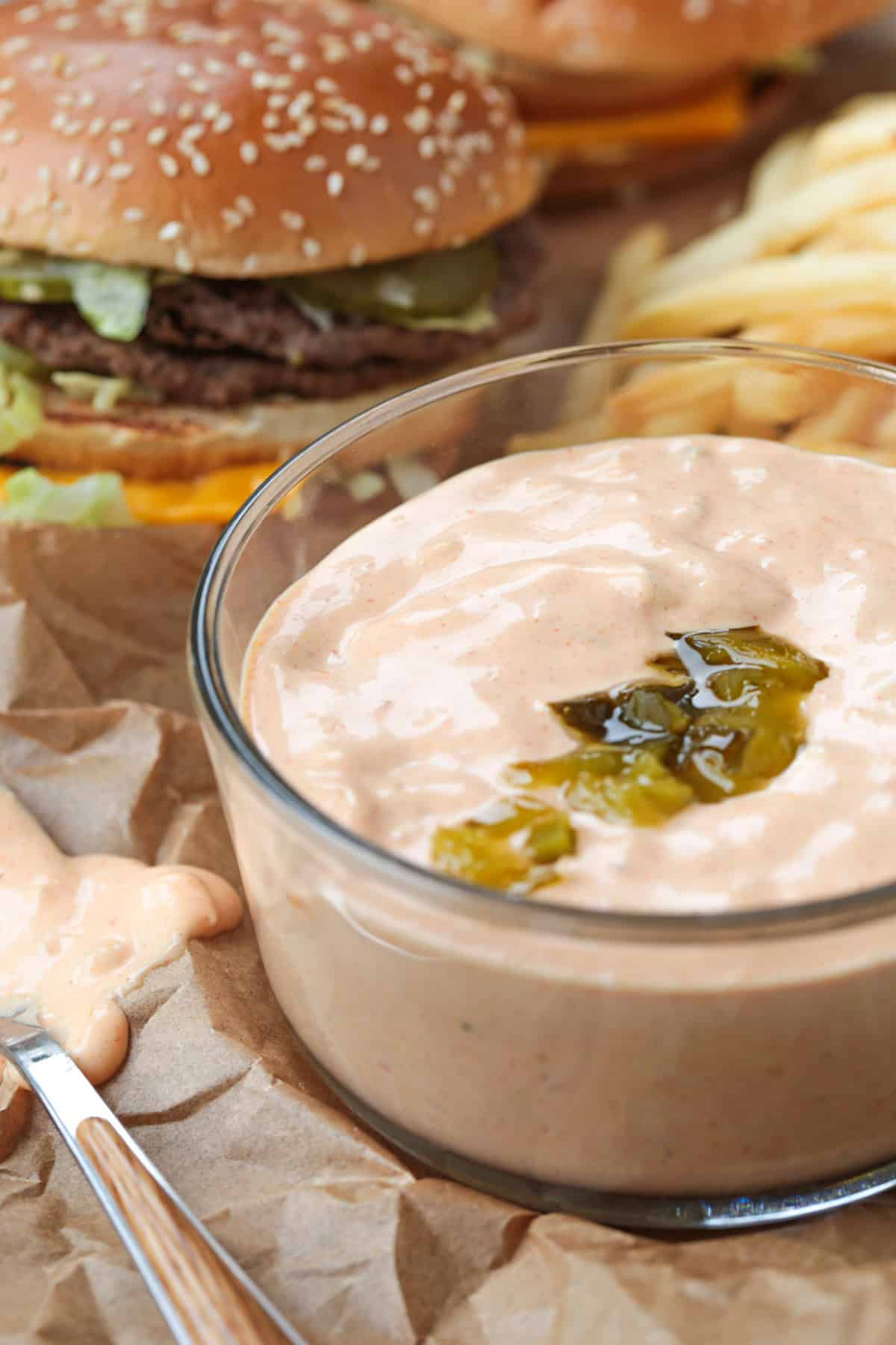 bowl of big mac sauce with a cheeseburger in background