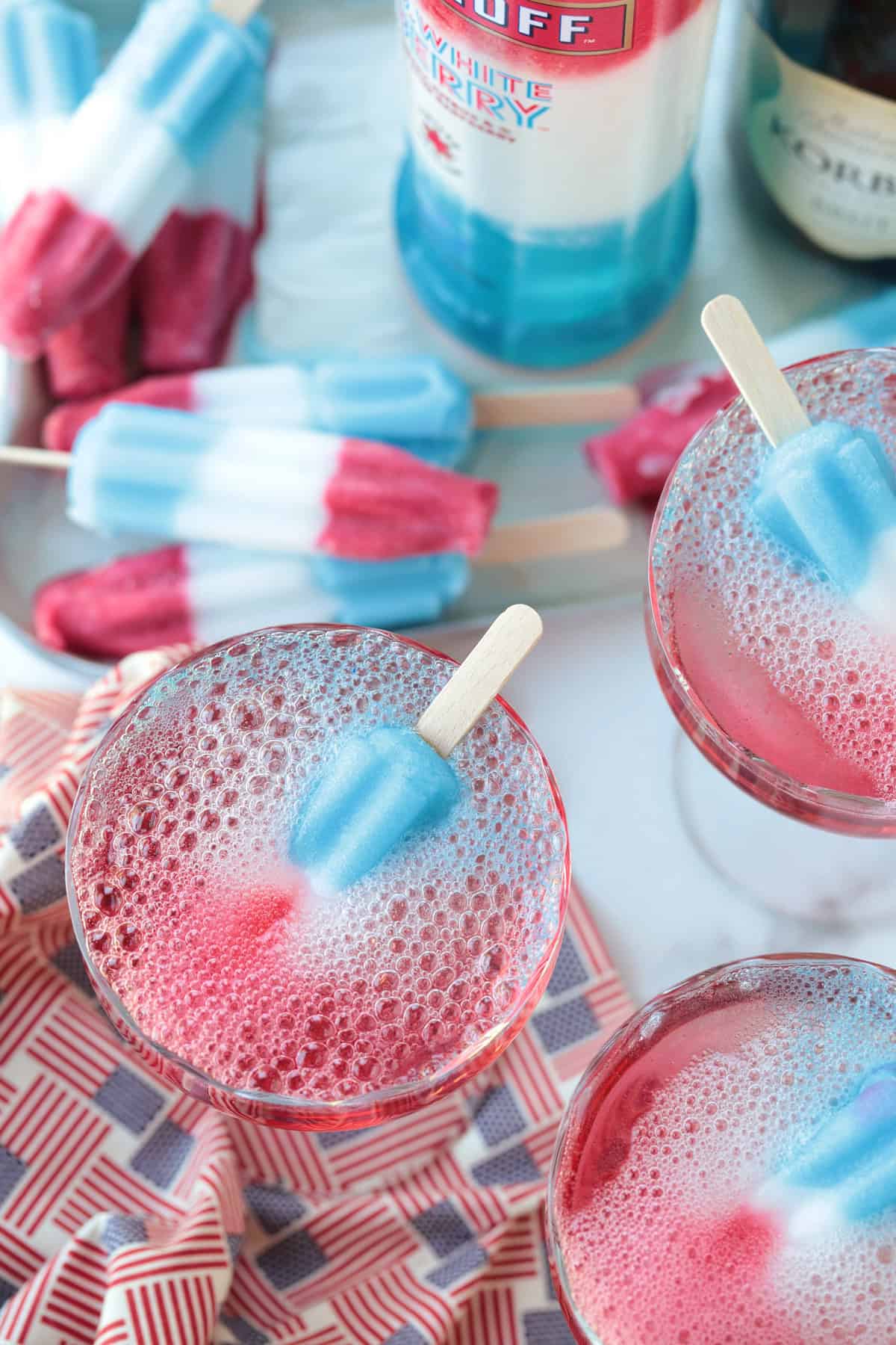 This Bomb Pop Cocktail is the easiest summer drink you'll ever make! The popsicle melts into the champagne for added fun and flavor! champagne cocktails with bomb pops inside