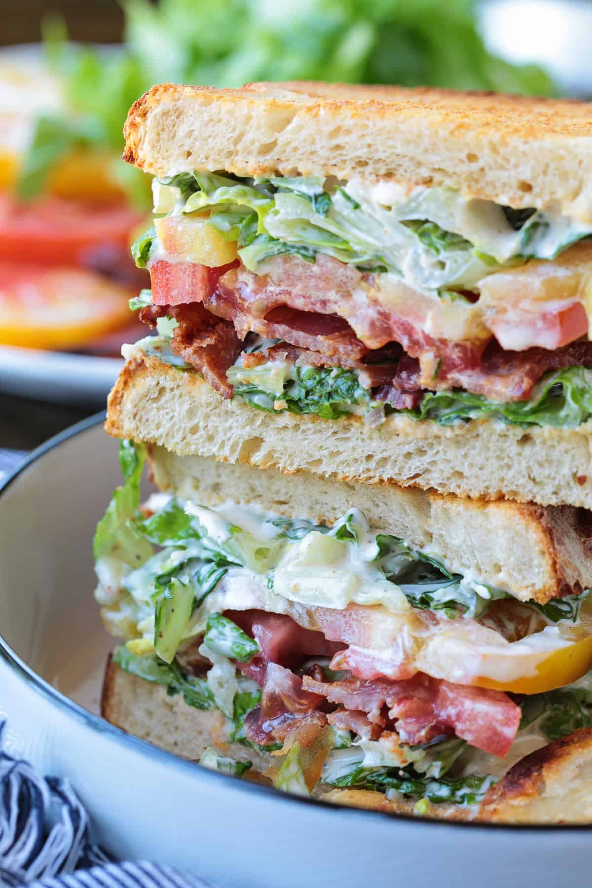 stacked blt sandwich on plate close up