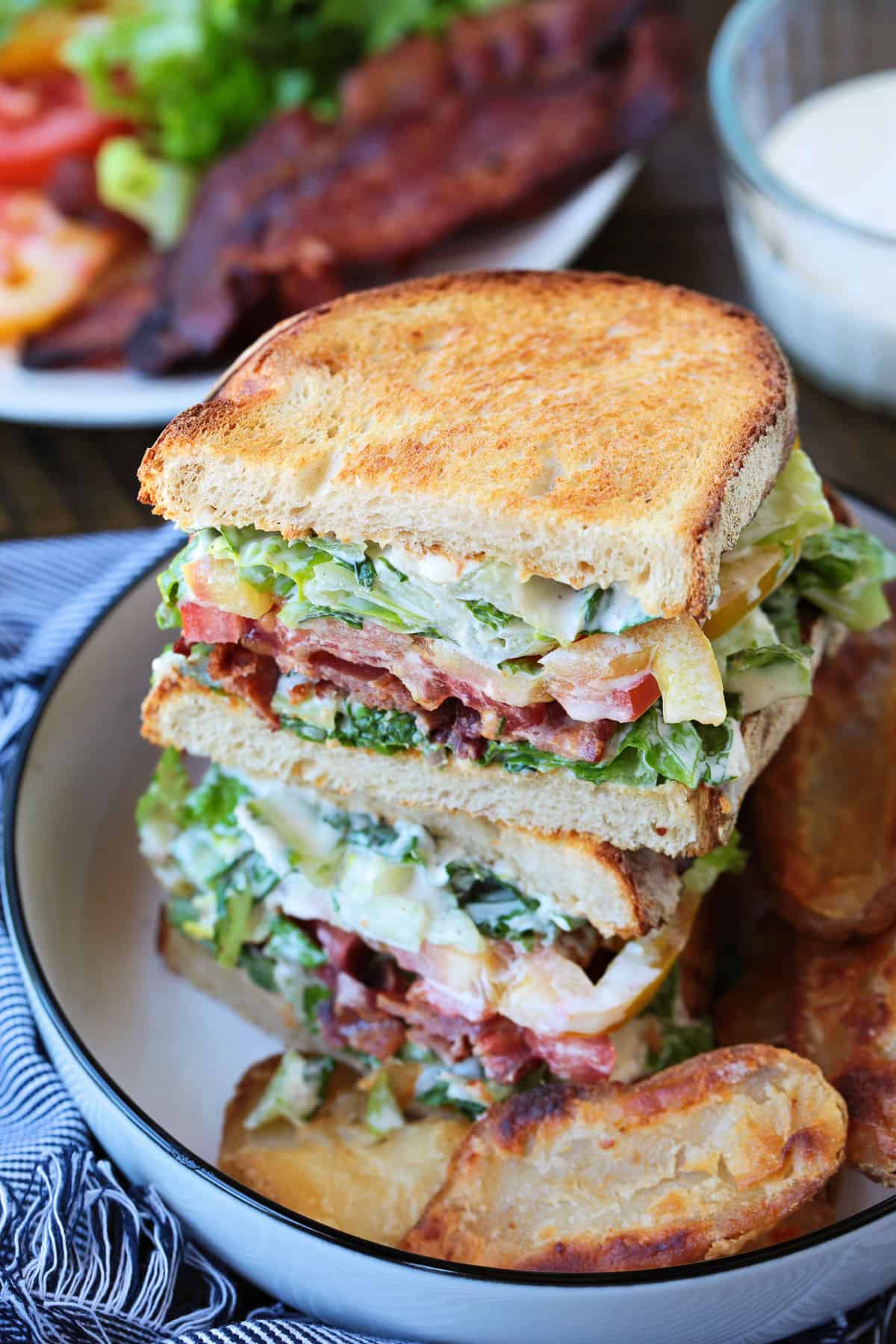 sliced blt sandwich on plate with chips